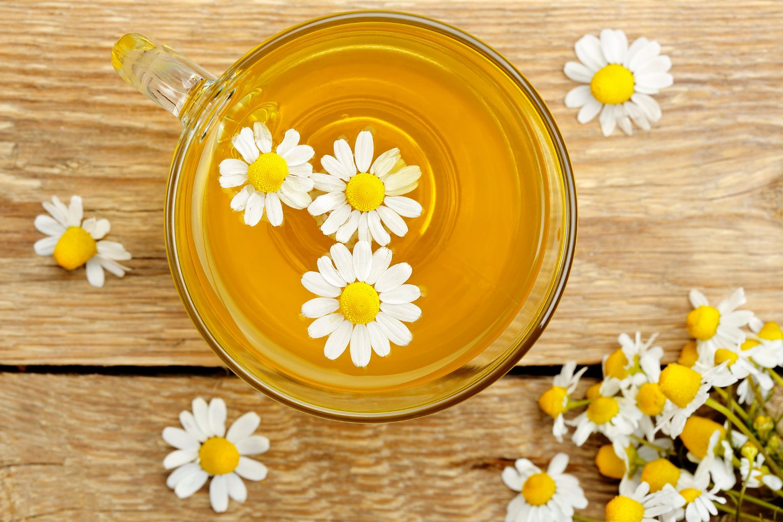 Taza con infusión de manzanilla y flores secas mostrando información sobre efectos secundarios