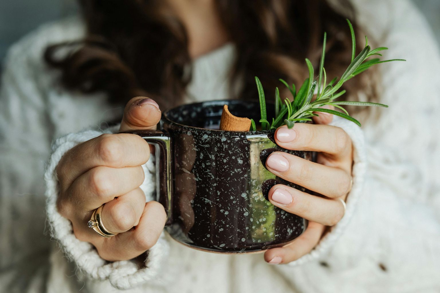 Taza con infusión de té de romero junto a ramas frescas de la planta