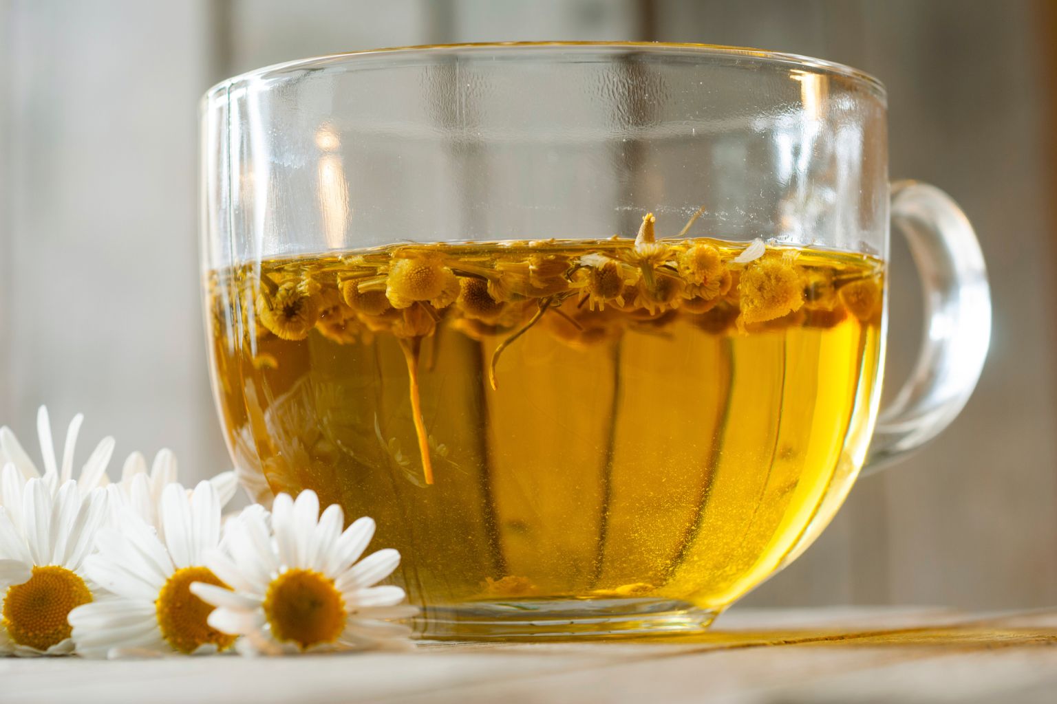 Taza de té de manzanilla con flores frescas para beneficios de salud